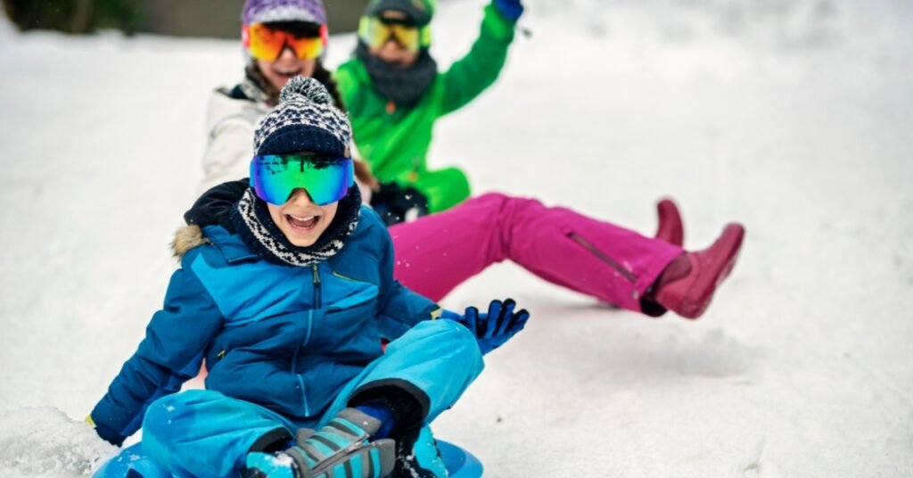 Children sledding on a Utah hillside, illustrating connection and self-preparedness through safe winter outdoor play.