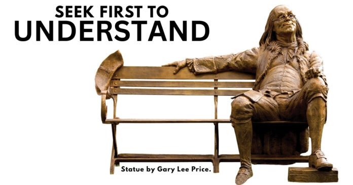 he statue of Benjamin Franklin sitting on a park bench, poised to listen that illustrates the powerful principle of seeking first to understand.