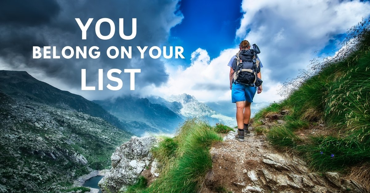 A person hiking forward on a mountain trail, with the overlaid text 'You Belong On Your List' to symbolize taking steps to self-love.