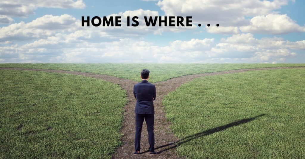 A man standing at a fork in a grassy path with the words "Home is where" above him, symbolizing the duality of belonging and the personal definition of home.