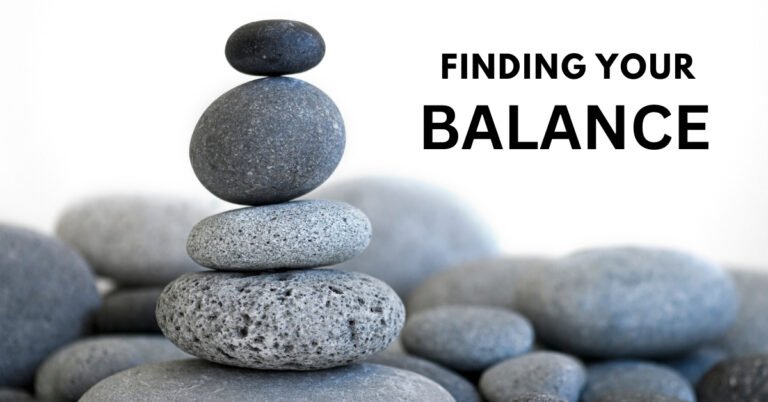 A stack of balanced stones on a peaceful beach, representing the need to find your balance and recover from emotional burnout.