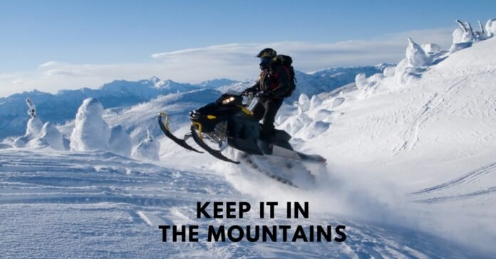 A snowmobile carving through deep mountain powder, illustrating the 